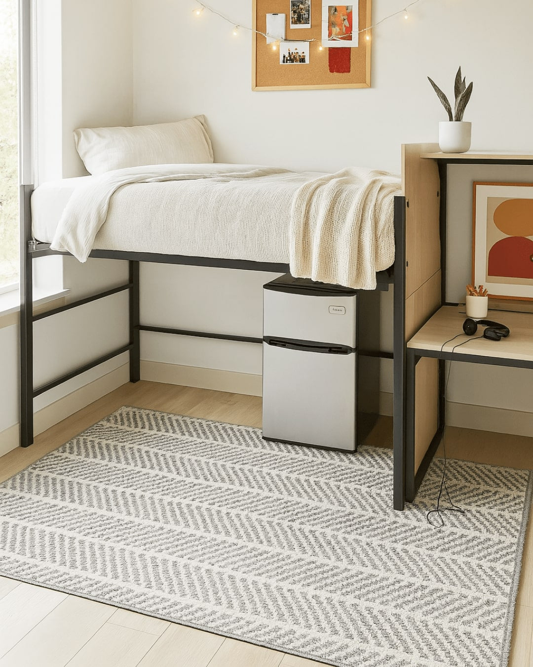 Small bedroom with a loft bed, desk, and small refrigerator, and a grey custom rug with stripes anchoring the room.