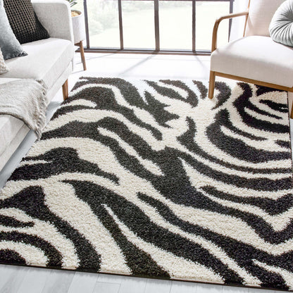 Safari Zebra Black Contemporary Shag Rug - Well Woven - A plush zebra-print rug with bold black and white stripes styled in a modern living room with light wood furniture.