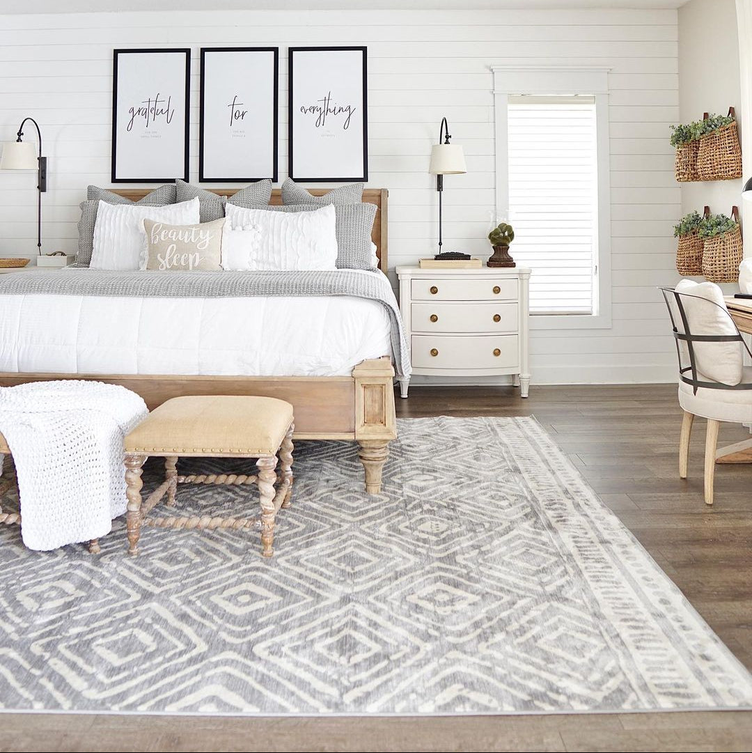 Neatly arranged bedroom with a bed, nightstands, and decor elements.