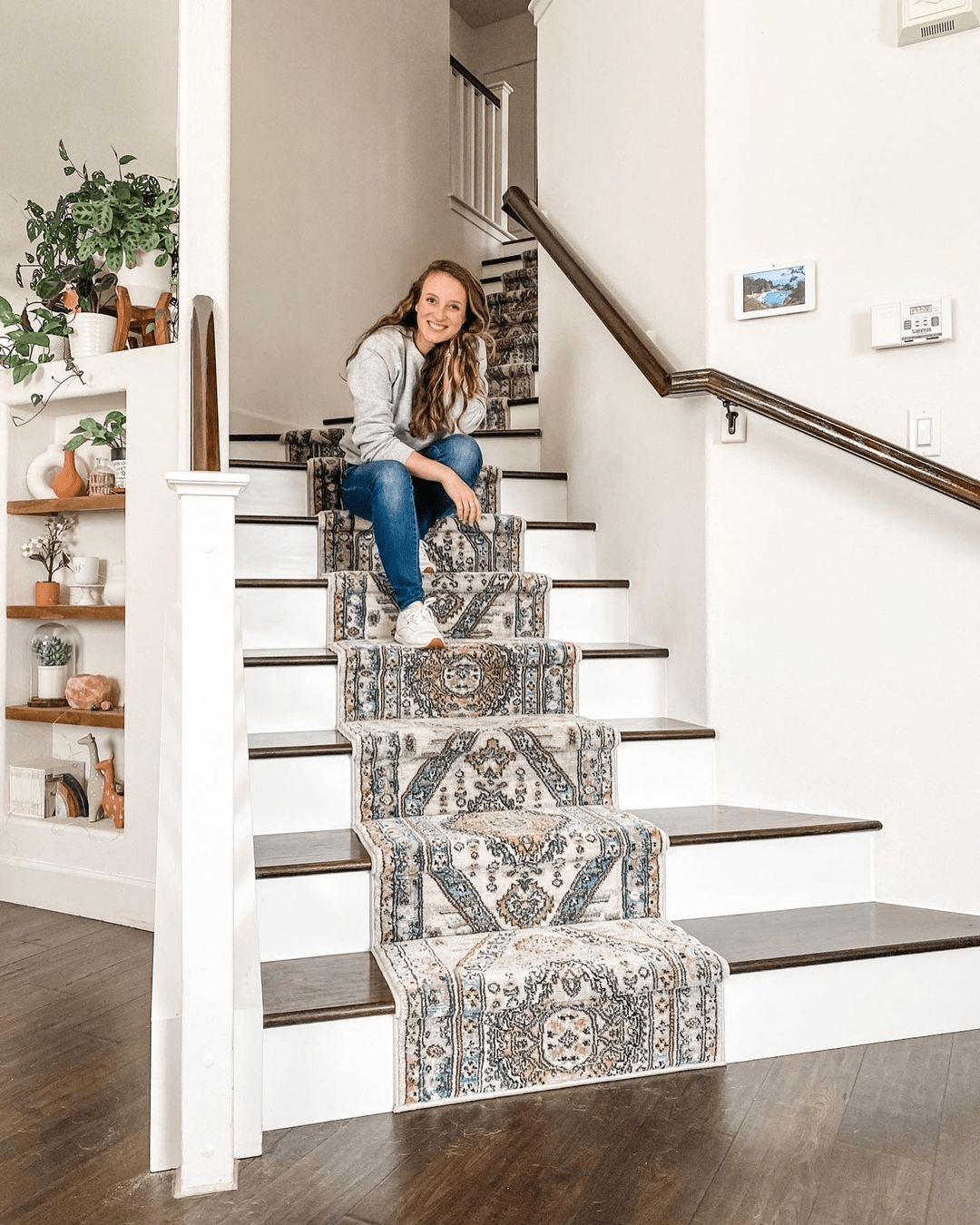 Woman sitting on a staircase with patterned risers in a home setting